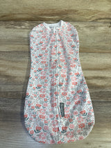 Flat-lay of newborn SwaddleMe pod swaddle showcasing pink floral pattern and front zipper on light wood background