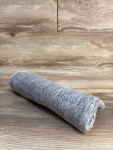 Gray heathered baby blanket rolled on wooden floor