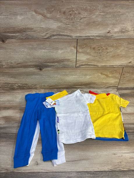 Flat lay of Toy Story 4-piece toddler pajama set with Buzz Lightyear and Woody shirts and blue and white pants on wood floor