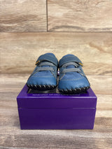 Front view of Pediped Dani navy crib shoes showing soft leather upper, Velcro strap and stitched soft sole on purple box