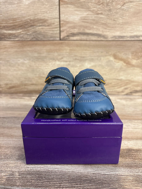 Front view of Pediped Dani navy crib shoes showing soft leather upper, Velcro strap and stitched soft sole on purple box