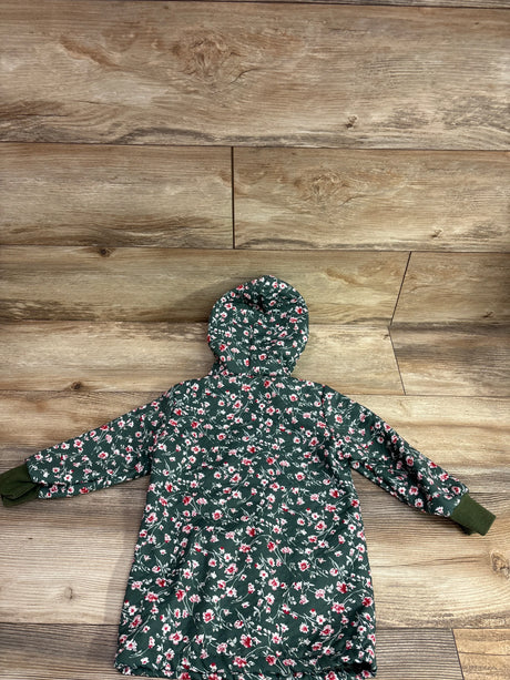 Back view of green floral fur lined button-up dress coat showcasing hood and ribbed cuffs with wood plank background