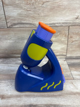 Side view of GeoSafari Jr. microscope with blue body, purple eyepiece, orange button and lime accents on wood background
