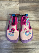 Top-down view of toddler water shoes showcasing embroidered mermaid on pink upper and purple rubber sole with wood floor background