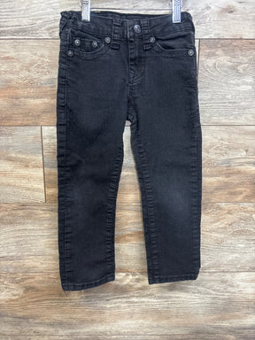 Black denim kids jeans with front pockets and belt loops on wood background