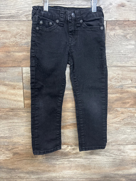 Black denim kids jeans with front pockets and belt loops on wood background