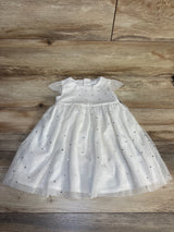 White baby dress with short sleeves and silver polka dots on wood floor background