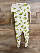 Back view of white Old Navy footed sleeper with green dinosaur print, size 12-18 months, hanging on wooden background