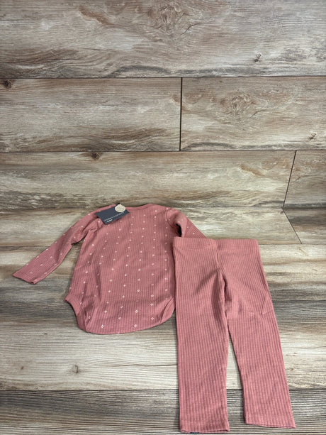 Flat lay of red ribbed 2-piece baby set, long-sleeve bodysuit with white dots and matching ribbed pants on wood background