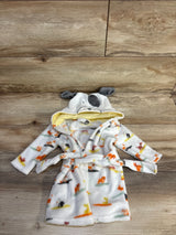 Flat lay of white baby plush robe showing dog-print pattern, hood with embroidered dog face and gray ears, and tie belt on wood background