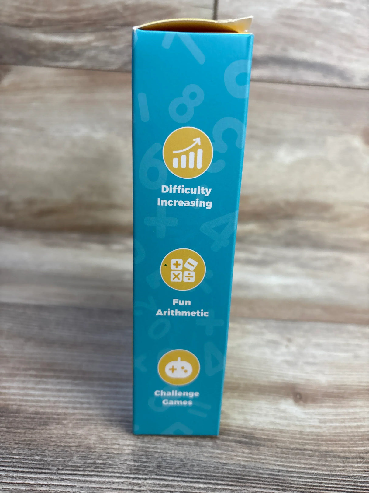 Blue box for kids' arithmetic game with increasing difficulty, fun math challenges, on wood surface