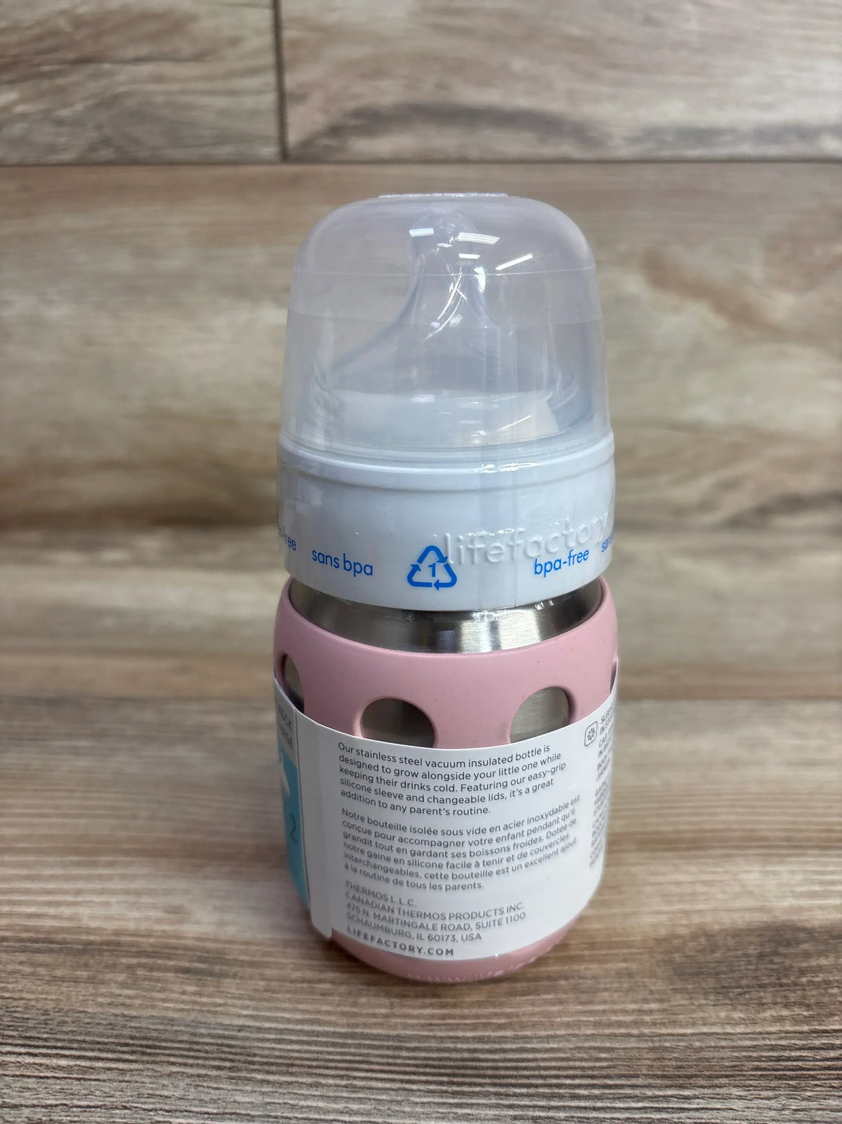 Pink stainless steel vacuum insulated baby bottle with silicone sleeve and clear plastic nipple cover