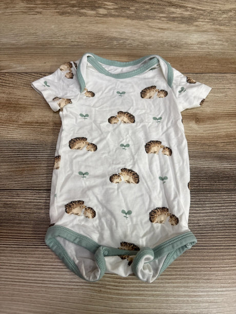 Front view of Kyte Baby bamboo hedgehog bodysuit in white with sage trim, hedgehog print, and snaps on wood