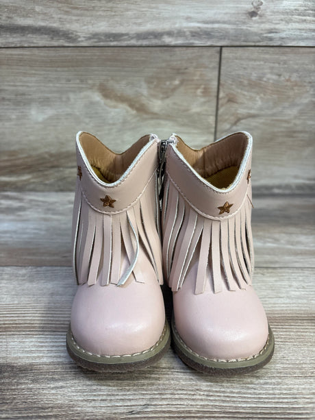 Front view of toddler pink round-toe cowgirl boots showcasing fringe and gold star studs with a wooden floor background