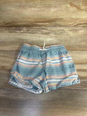 Front view of OshKosh boys' blue striped cotton shorts with elastic waistband and white drawstring on wood background
