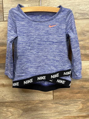 Blue Nike Dri-FIT long sleeve athletic top with black Nike logo waistband on wooden background