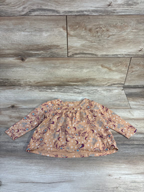 Brown long sleeve baby shirt with moon and star pattern on wooden floor