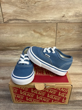 Three-quarter view of navy Vans toddler Authentic sneaker with white laces and rubber sole on Vans box wood background
