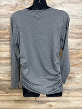 Gray long sleeve maternity top with ruched sides on mannequin, wood background
