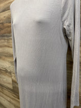 Close-up front of grey ribbed long-sleeve maternity dress on mannequin showing ribbed texture and long sleeves with wood background