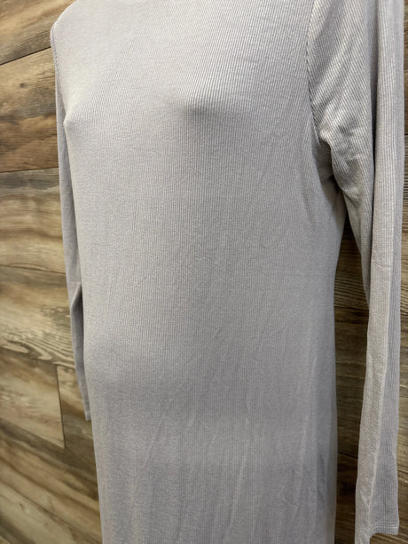 Close-up front of grey ribbed long-sleeve maternity dress on mannequin showing ribbed texture and long sleeves with wood background