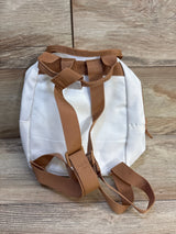 Small white kids backpack with brown adjustable straps on wood background
