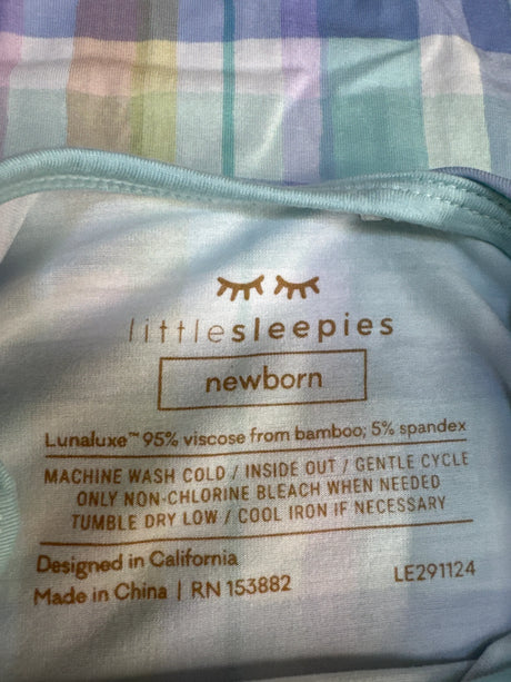 Close-up of Little Sleepies pastel plaid convertible bamboo sleep gown tag showing brand and care instructions on plaid fabric
