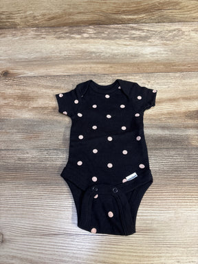 Top down view of preemie black Gerber bodysuit with pink polka dots, lap shoulder and snap crotch on wood background