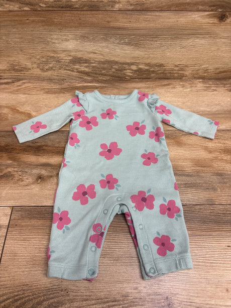 Flat lay of blue Just One You waffle knit coverall with pink floral print, long sleeves, and snap closures on wood