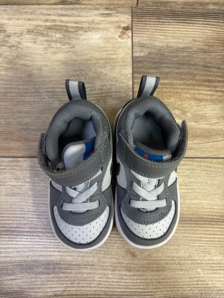 Top view of Nike Court Borough Mid TD sneakers showcasing grey, white, and blue panels with a wood-grain background