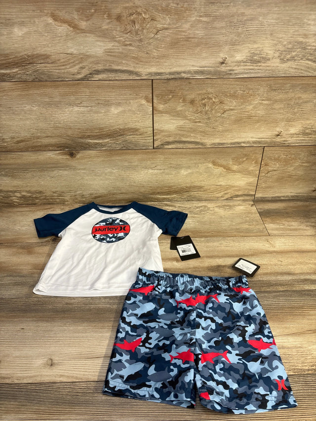 Front view of Hurley toddler 2-piece rashguard set: white shirt with navy sleeves and camo Hurley logo, blue camo shorts with red sharks