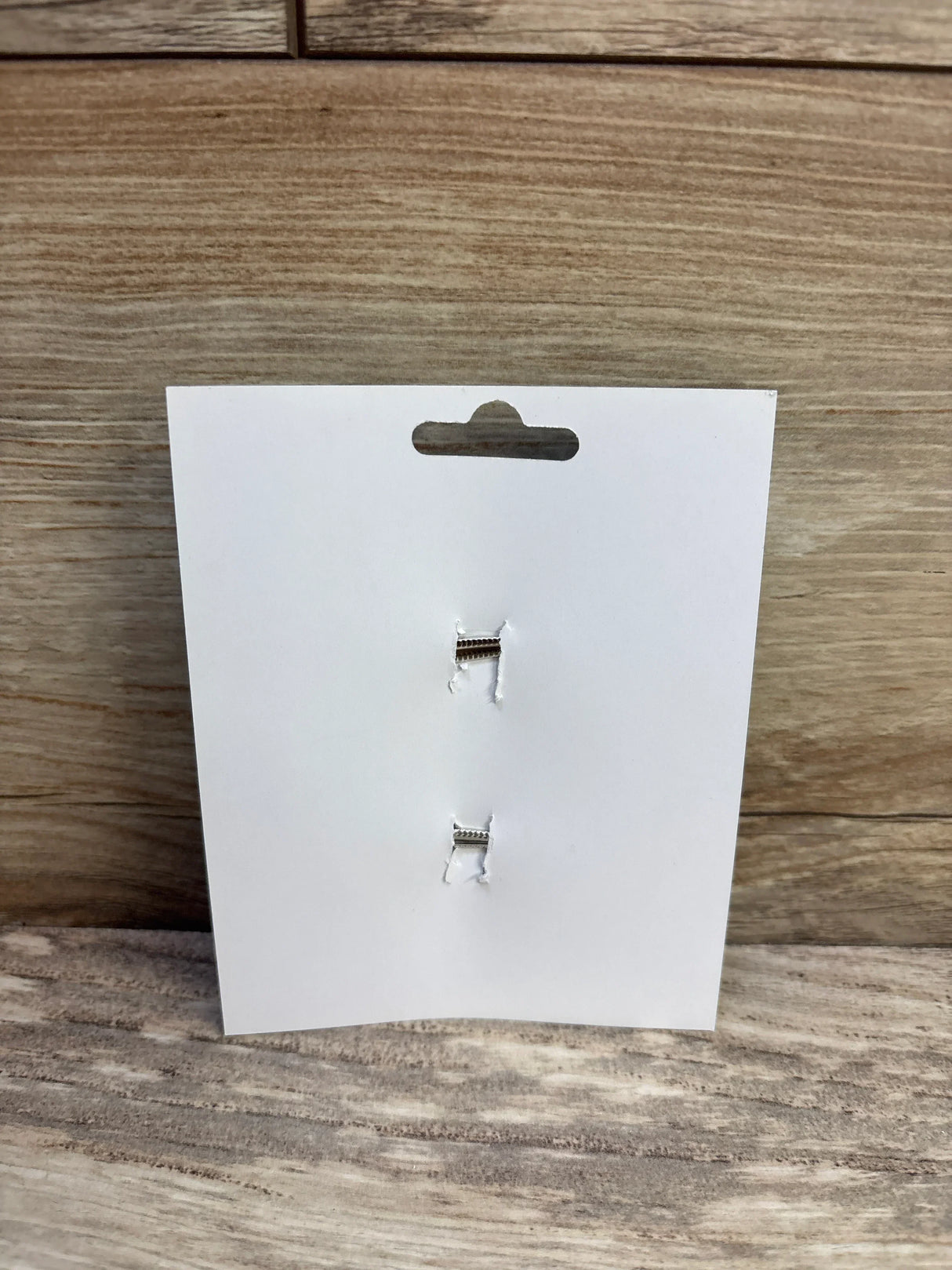 Front view of two hair bow clips on a white display card showcasing metal alligator closures against a wood-grain surface