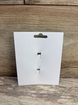 Front view of two hair bow clips on a white display card showcasing metal alligator closures against a wood-grain surface