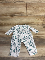Flat lay of white baby coverall size 6-9 months showing green leaf print and long sleeves on wood background
