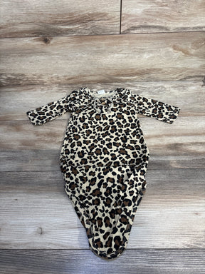 Leopard print baby bodysuit with long sleeves on wood background
