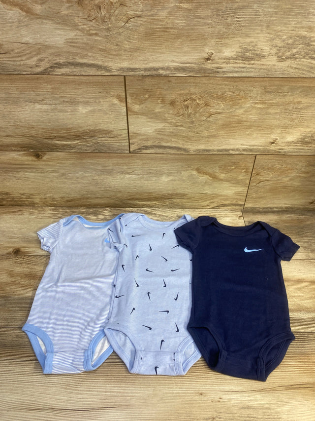Front view of three Nike bodysuits in striped light blue, Nike print, and navy designs, size 18 months, on a wood floor