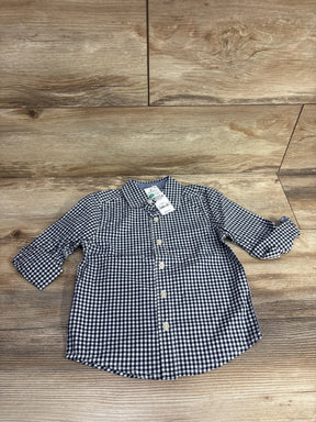Navy and white plaid long sleeve button-up toddler shirt on wood background