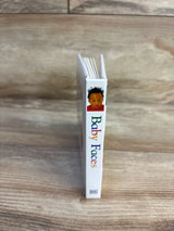 Spine view of Baby Faces DK board book showing colorful title text and infant cover photo standing on wood plank floor