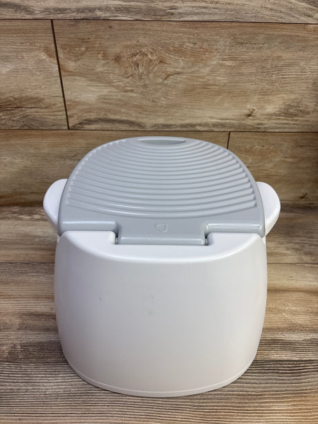 Angled view of Munchkin Arm & Hammer Multi-Stage 3-in-1 Potty showcasing its gray textured lid and white body against wood