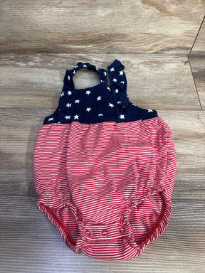 Front view of size 12M bubble romper with navy star-print top, ruffled straps and red and white striped bottom on wood background