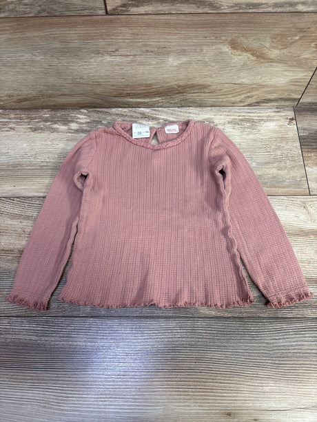 Top view of Zara pink long sleeve knit shirt, size 3 to 4T, showcasing ribbed texture and frayed hem on wood