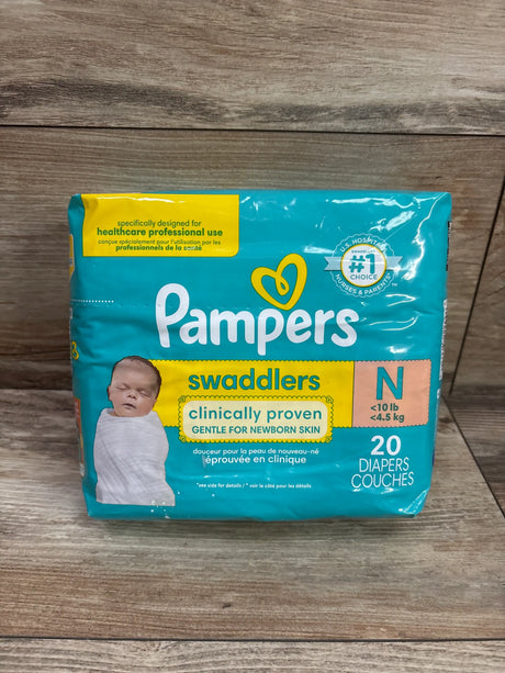 Front view of Pampers Swaddlers newborn diapers, 20 count, with clinically proven gentle newborn skin packaging on wood