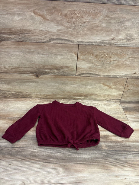 Front view of Cat & Jack waffle knit shirt in maroon showcasing long sleeves and a tie-front hem on a wood-look background