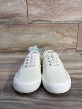 Front view of Cat & Jack Tyler toddler slip-on sneakers in off-white, size 13C, showing textured white rubber soles and elastic laces on wood background