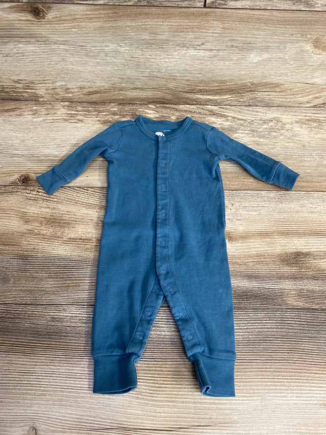 Blue long sleeve baby romper with snaps, laid flat on wooden background