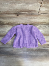 Purple knit toddler sweater with long sleeves on a wooden background