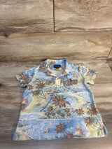 Flat lay of Polo Ralph Lauren tropical beach polo jersey in blue showcasing palm trees and sailboat print on wood plank floor