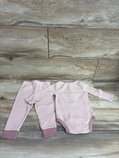 Top view of Cloud Island pink textured henley bodysuit and pants set for 6 to 9 months showcasing ribbed fabric on a wood surface