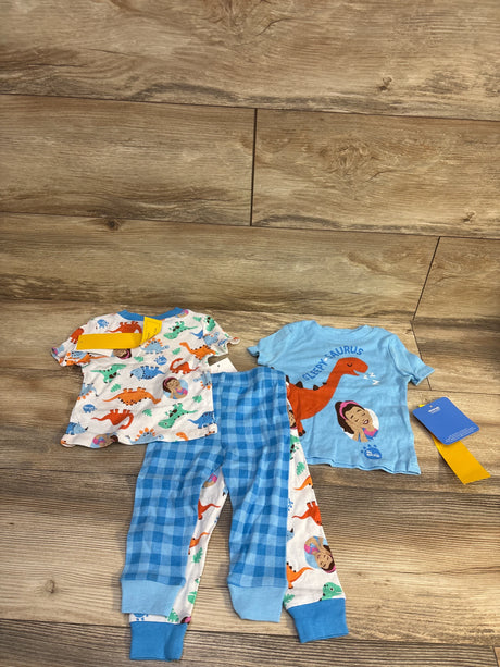 Flat lay of Ms Rachel 4-piece snug-fit baby pajama set showing two dinosaur-print tops and two matching pants on wood floor