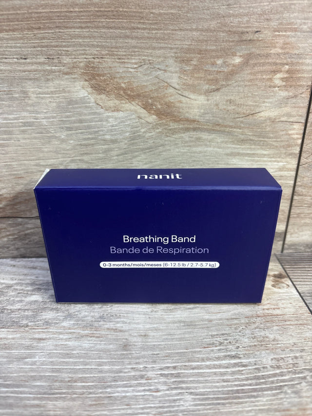 Front package view of NEW Nanit Breathing Band size 0-3m showcasing navy blue box labeled 6-12.5 lb on wood plank backdrop